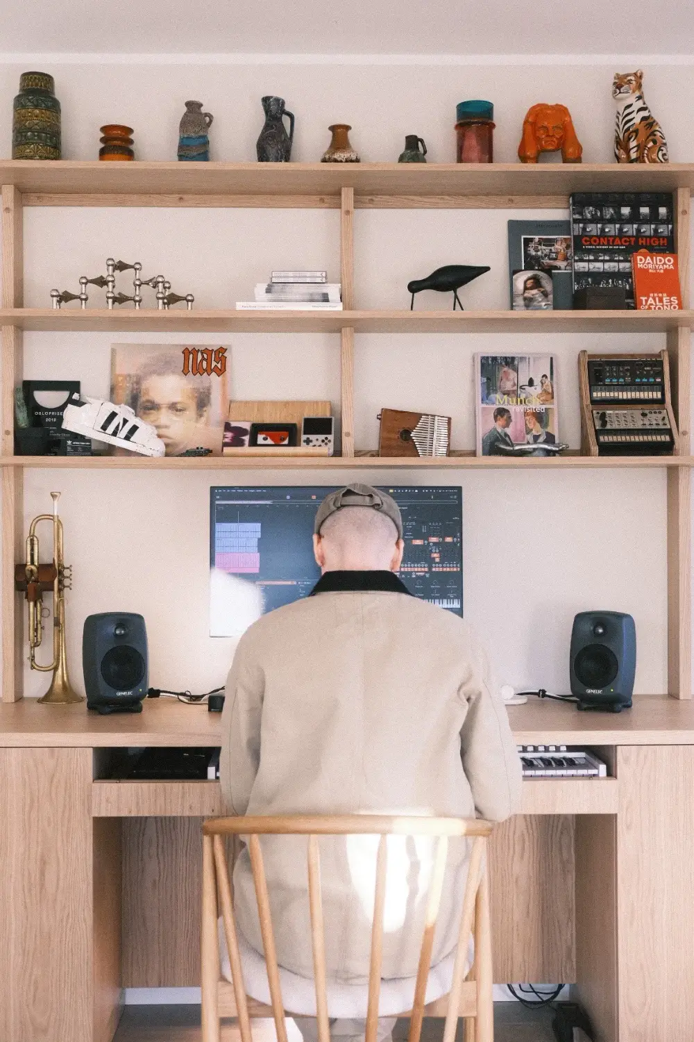 Kristoffer Eikrem at the studio desk, seen from behind, with Genelec monitors and Ableton Live on the screen
